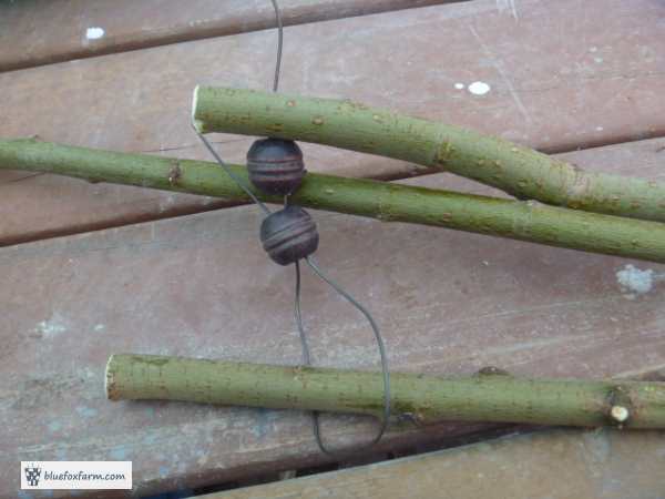 Three twigs for legs, with beads in between