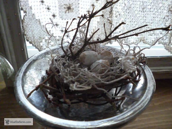 A rustic twig gives support to the faux birds nest