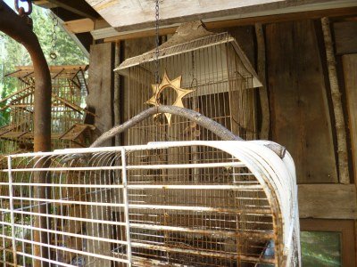 Wiggly twig handle embellishes this great bird cage...