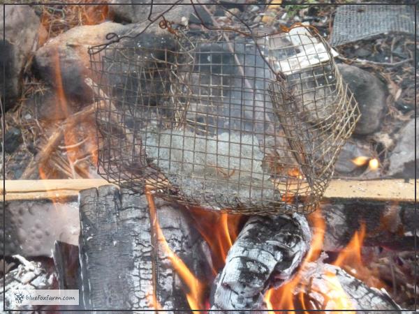 Broken piece of hypertufa pot in a metal basket over the flame