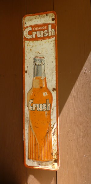 A rustic example of the common Orange Crush tin sign