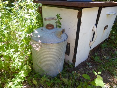 Zinc gasoline can beside the (thankfully!) non-working vintage wood stove